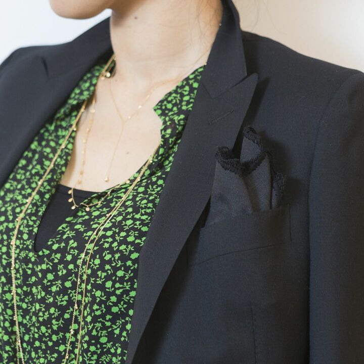 やわらかいシフォン素材のワンピースには、あえて質感の違う固め素材のリネンチーフを差すことで、モダンな印象に。「黒ジャケットに寄り添って同化するブラックカラー、そして、ボヘミアンテイストのドレスと好相性の縁取りレースディテールが、洗練されるポイントです」