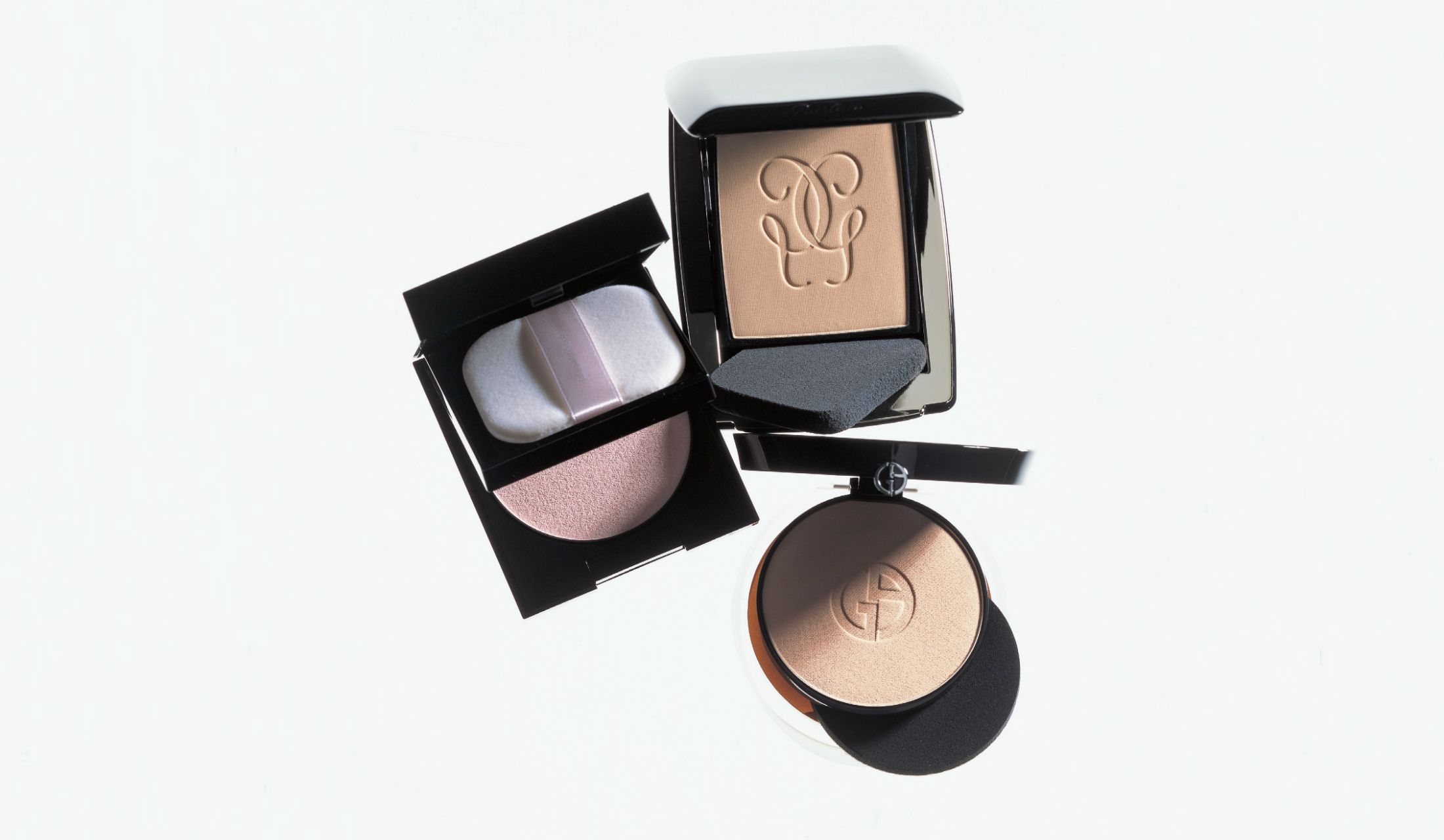 上/ゲラン パリュール ゴールド コンパクト 01 SPF15・PA++ ¥11,500、左上/SUQQU フェイス アップ ブライト パウダー¥6,000(販売終了)、下/ジョルジオ アルマーニ ビューティ ルミナス シルク コンパクト ファンデーション 4 ¥9,000