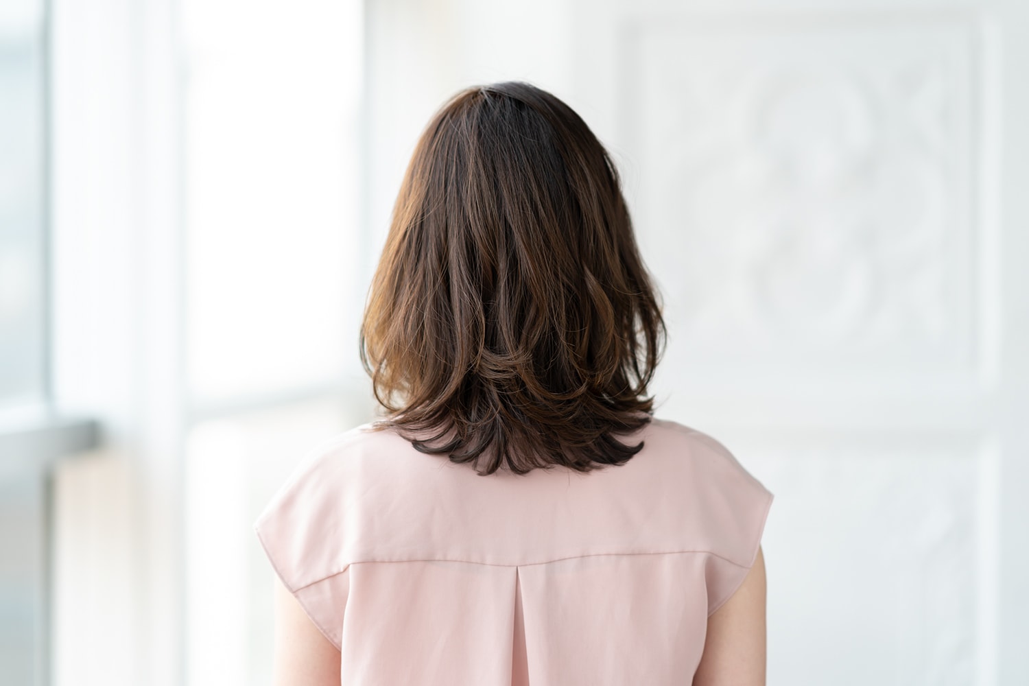 「ベースはローレイヤースタイル。顔まわりにレイヤーと段を入れ、髪の中間を間引くことで、軽やかなニュアンスが出るようにカットしています。サイドは長めに残し、アイロンやパーマで動きを出してあげると、顔の輪郭からより目線を逸らすことができます」(本木さん)