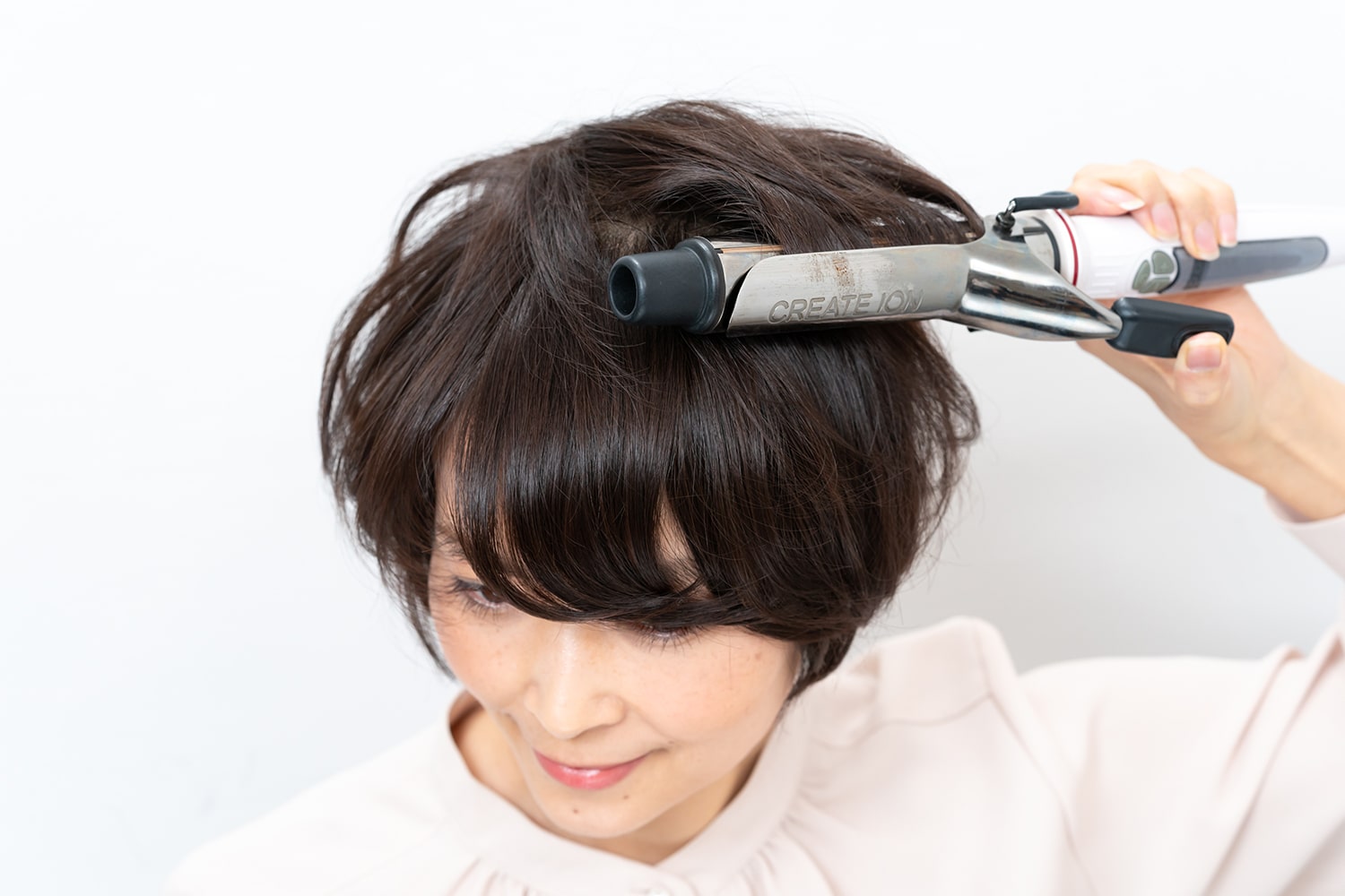 頭頂部の髪を中間から毛先にかけて内巻きに。