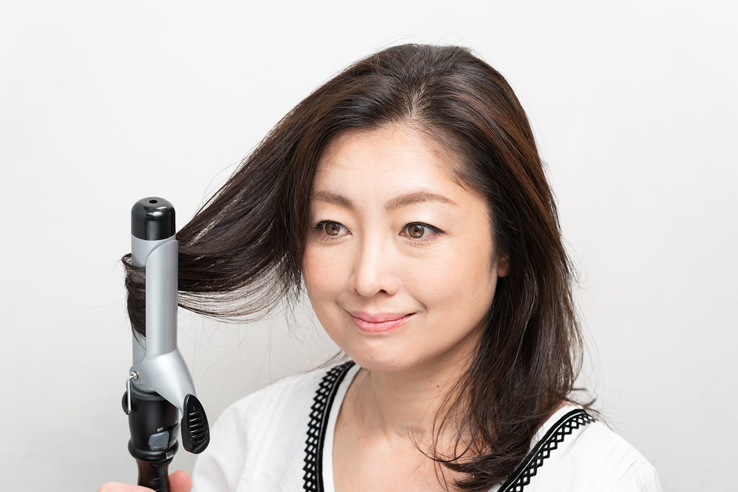 コテは32mmを使用。髪全体の毛先を内側にワンカールする。