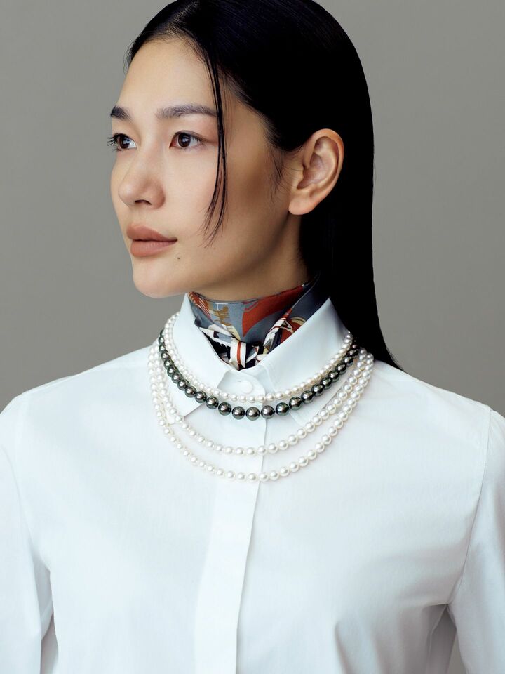スカーフとパールネックレスをレイヤードしたモデルの大塚まゆかさん