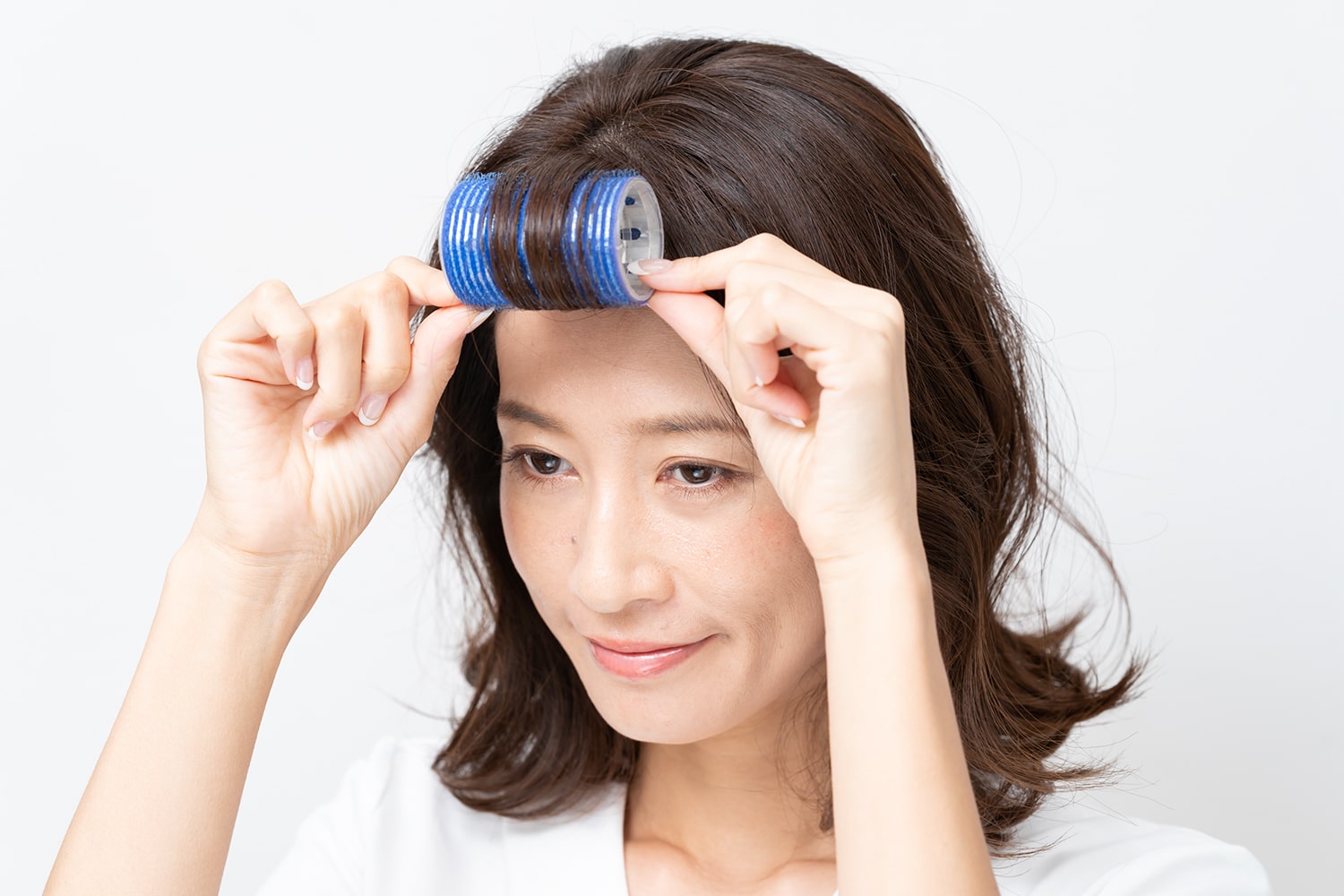 毛先から根元までしっかりと巻く。巻いたらドライヤーで熱風を当て、その後10分ほど放置する。