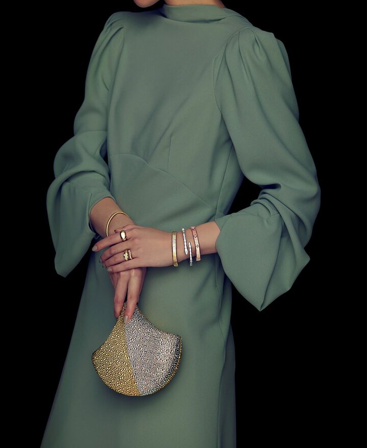 「ブルガリ」のバッグとジュエリーを纏った女性の手元