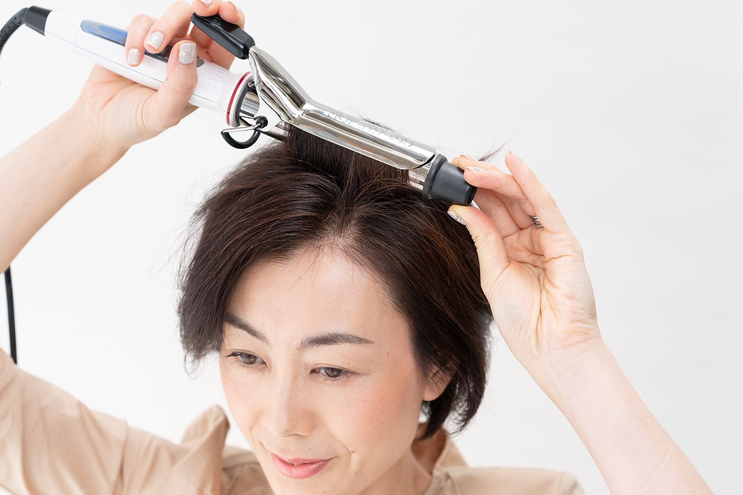 アイロンは32mmを使用。前髪のすぐ後ろをざっくりと取って後頭部に向けてワンカール巻く。前髪が立ちにくい時は前髪も同様に。