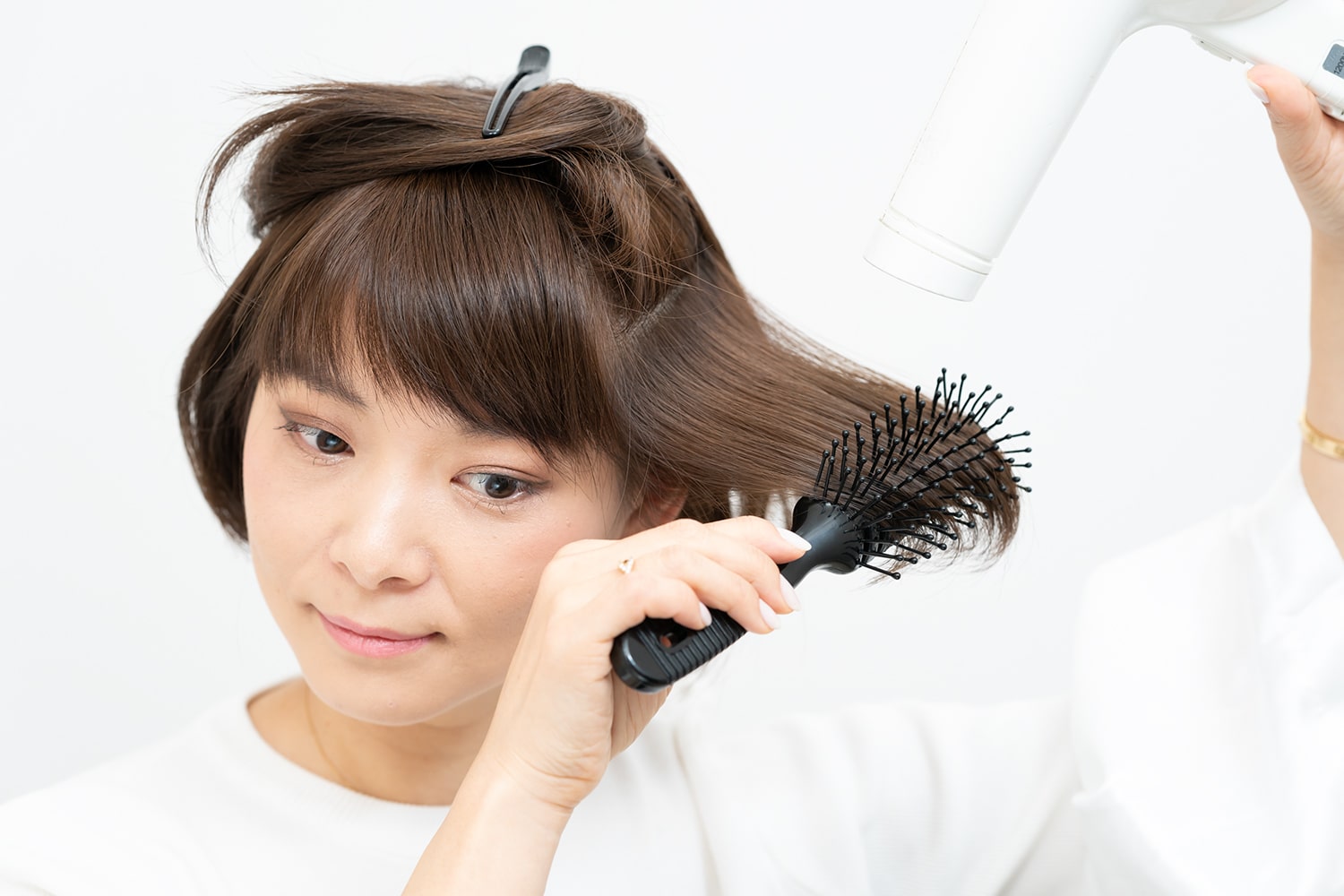 ブラシの面に対して正面から熱風を当てるのがコツ。ブラシの丸みで自然なカールに。逆サイド、後頭部も同様に。その後、上段の毛束も同じようにブローして。