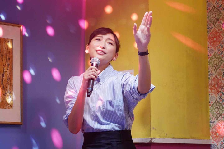 パリッとしたシャツに身を包み、仕事帰りにカラオケで熱唱する濱 鐘子　©︎日本テレビ