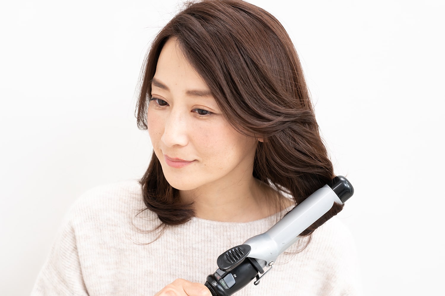 アイロンは32mmを使用。毛束をざっくりと取ってワンカールすると、アイロンの熱で髪にツヤが出る。逆サイドと後ろも忘れずに巻いて