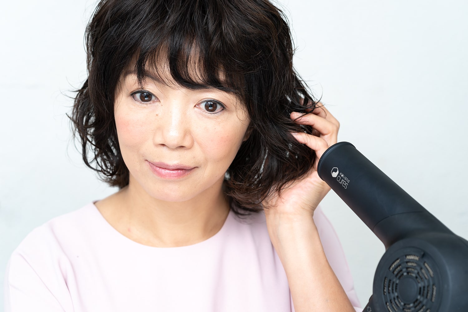 パーマを復活させるようなイメージで、毛先を中心に軽く握る。