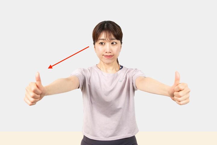 顔は正面のまま、伸ばした腕の右の親指を見る