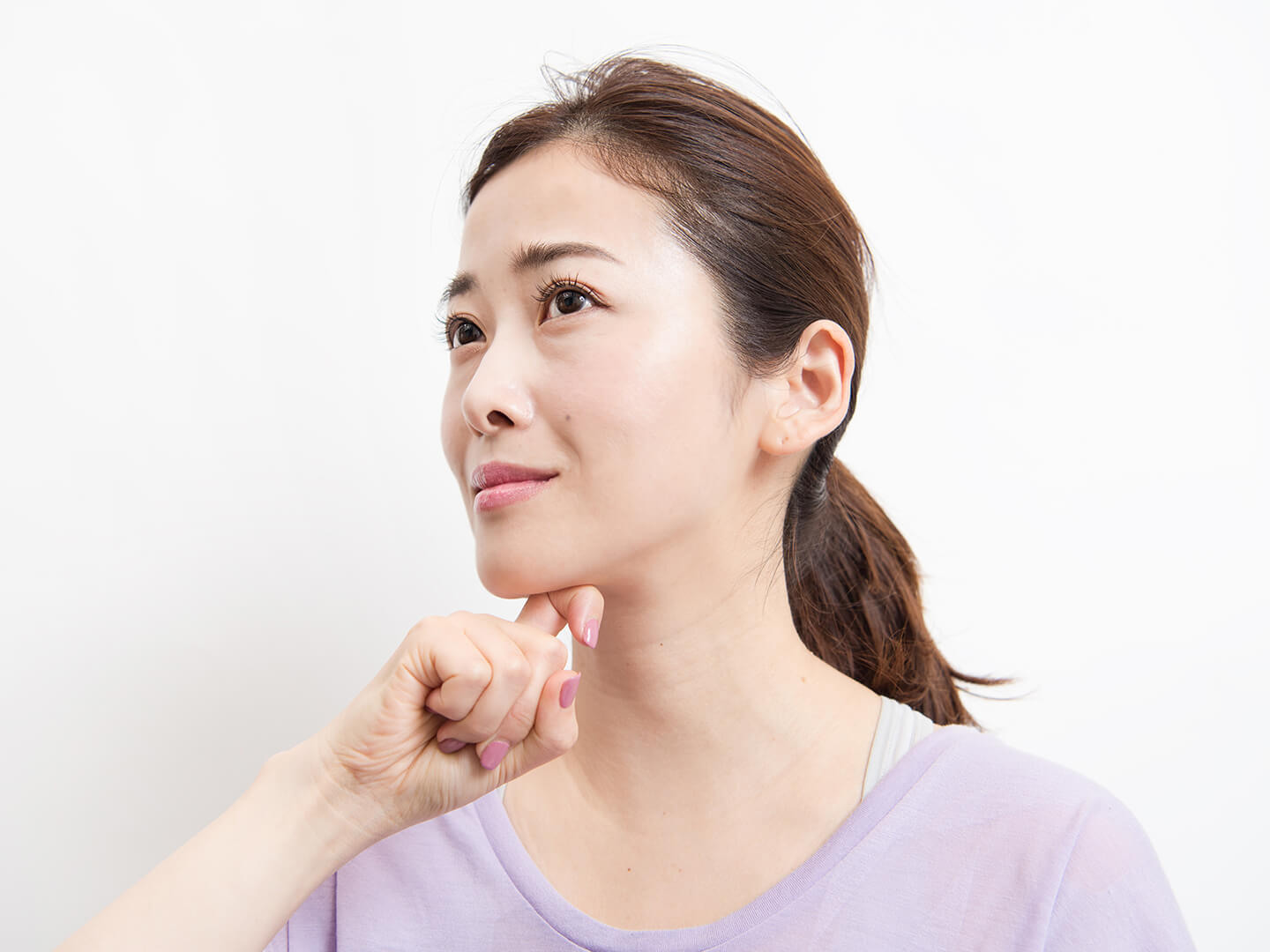 指をあご下に当てている女性
