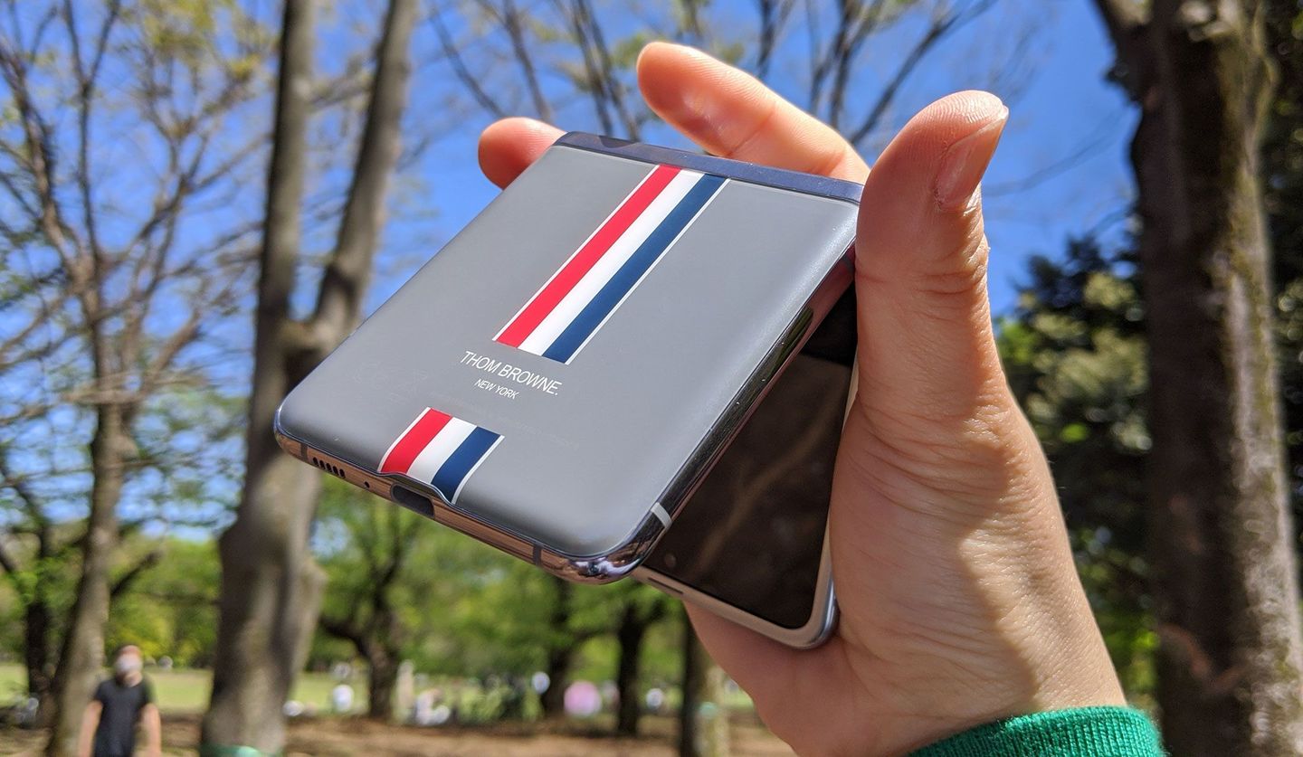 トム ブラウンとコラボしたスマートフォン「Galaxy Z Flip Thom Browne Edition」を持っている画像