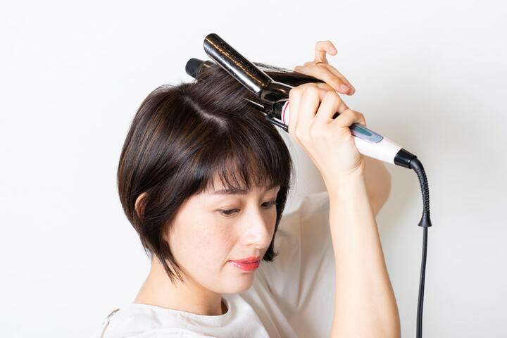 トップの髪の根元を起こすように、太めのヘアアイロンを当てて、ボリュームを出す。
