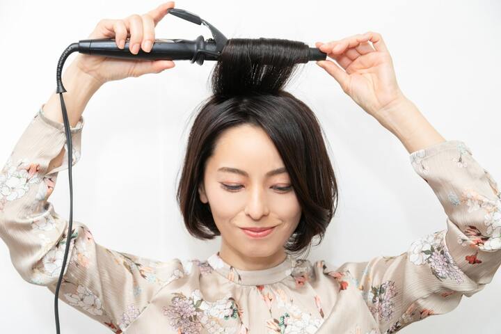 髪表面の髪をトップに集めて、毛先から水平に巻き込む。オイルを手のひらに薄くのばして髪全体になじませて完成。