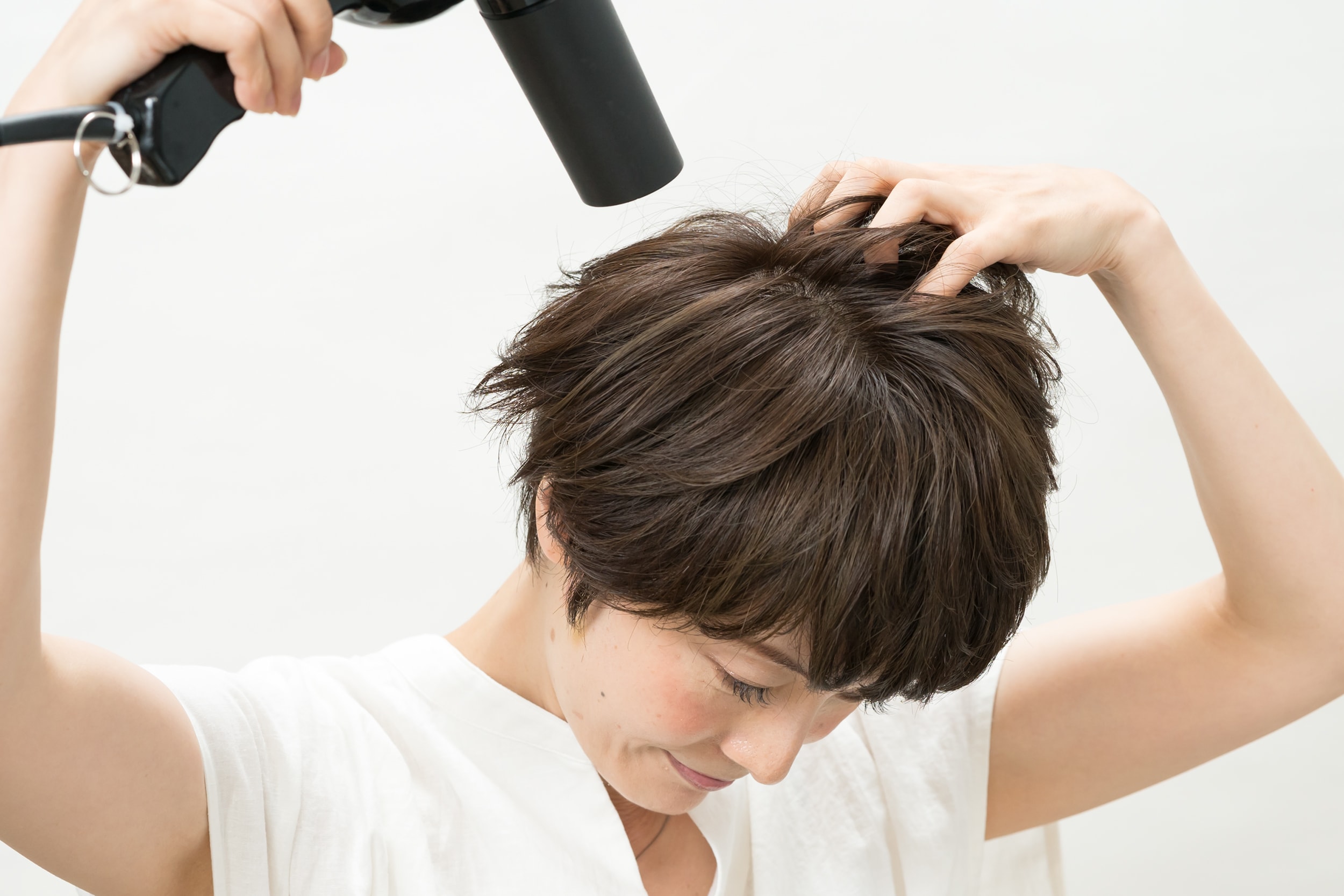 分け目をつくらないよう、つむじ周りをメインに根元をこすりながらドライヤーを当てて。