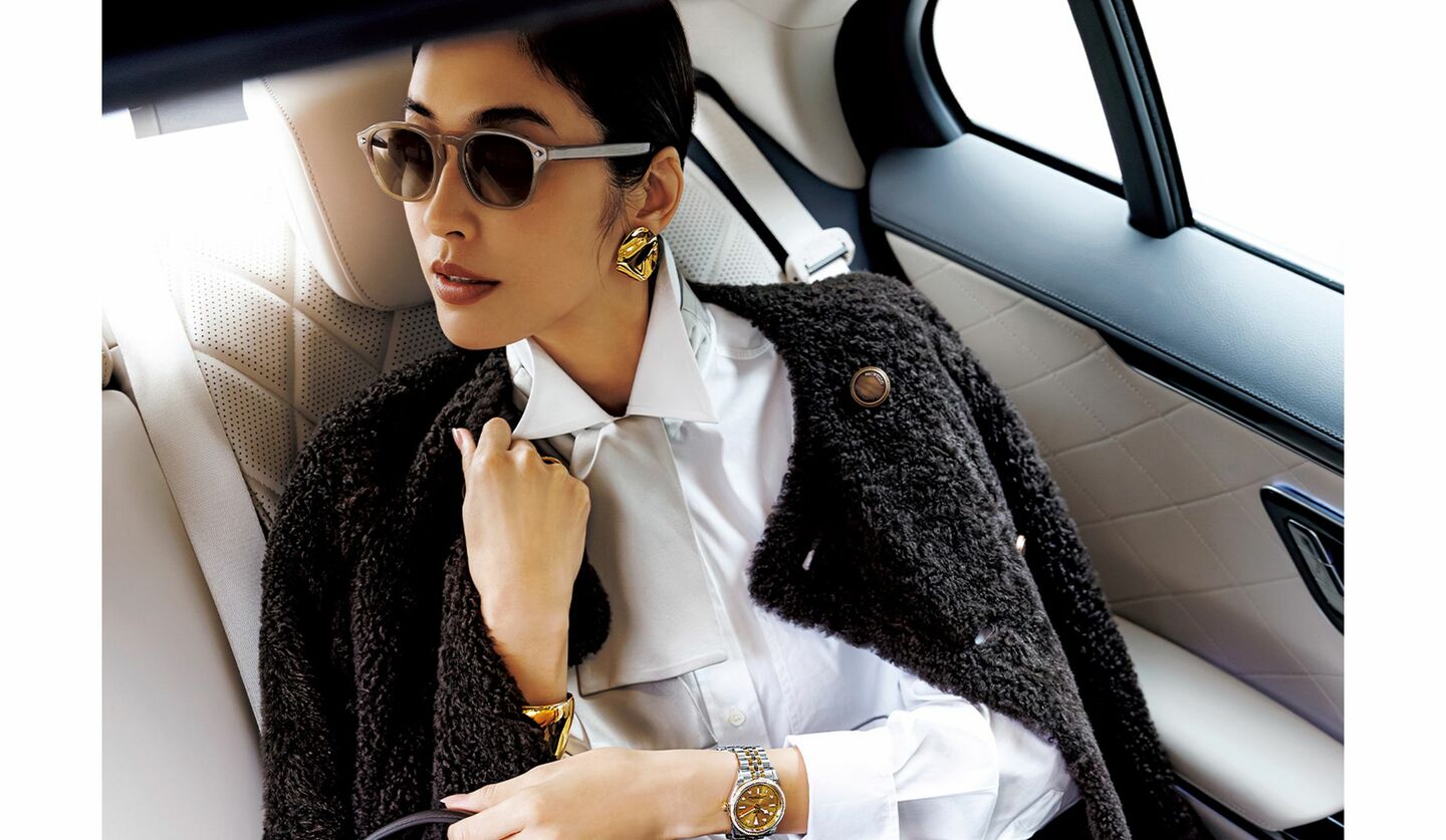 ブルネロ クチネリのムートンジャケットを羽織って自動車内に座るモデル