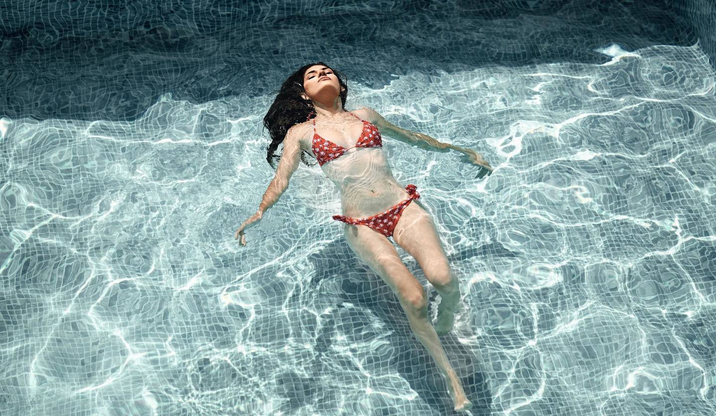 水着でプールに浮かぶ女性