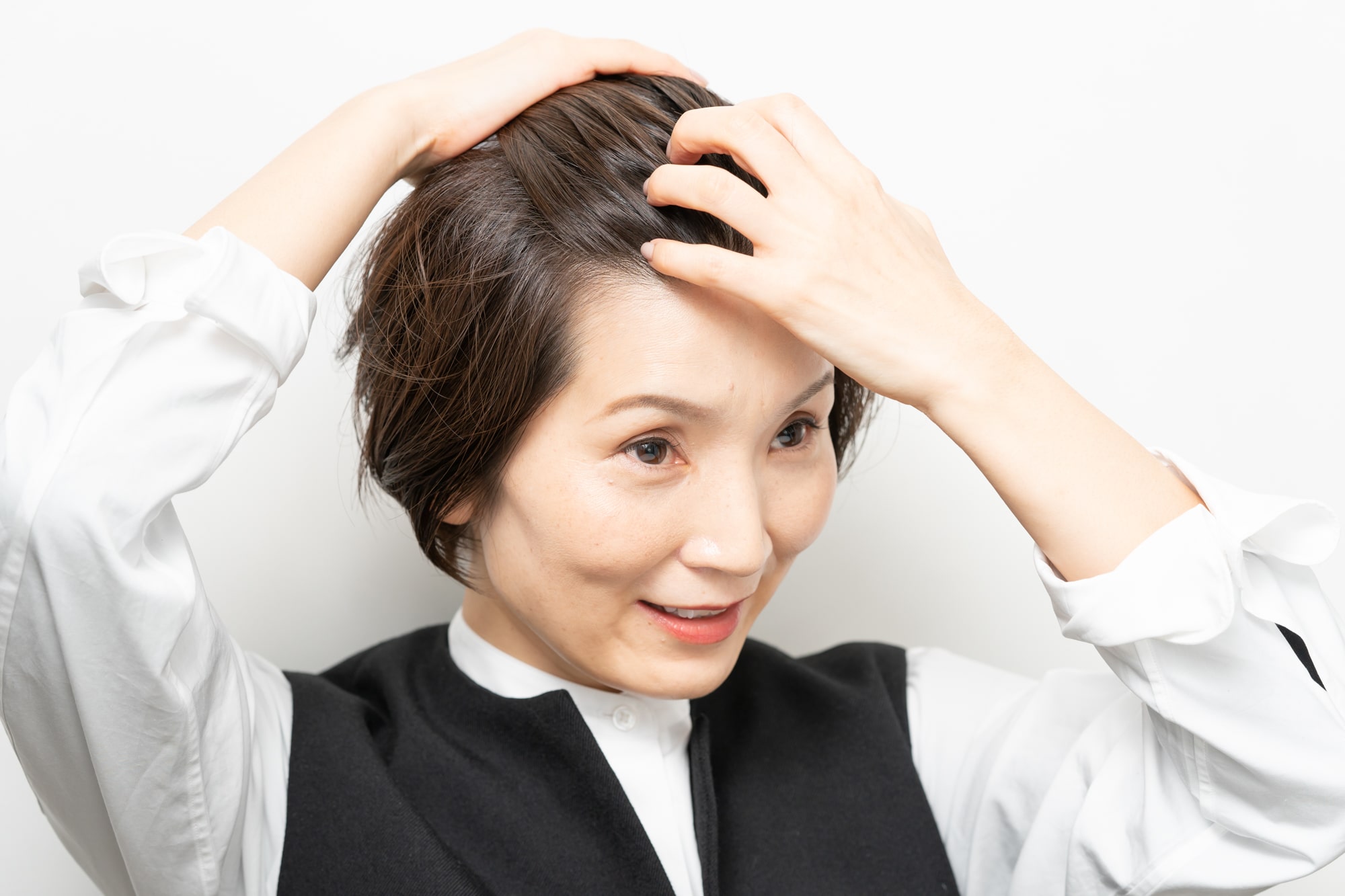 手のひらにスタイリング剤を広げ、オールバックにするようにとかしながらなじませる。