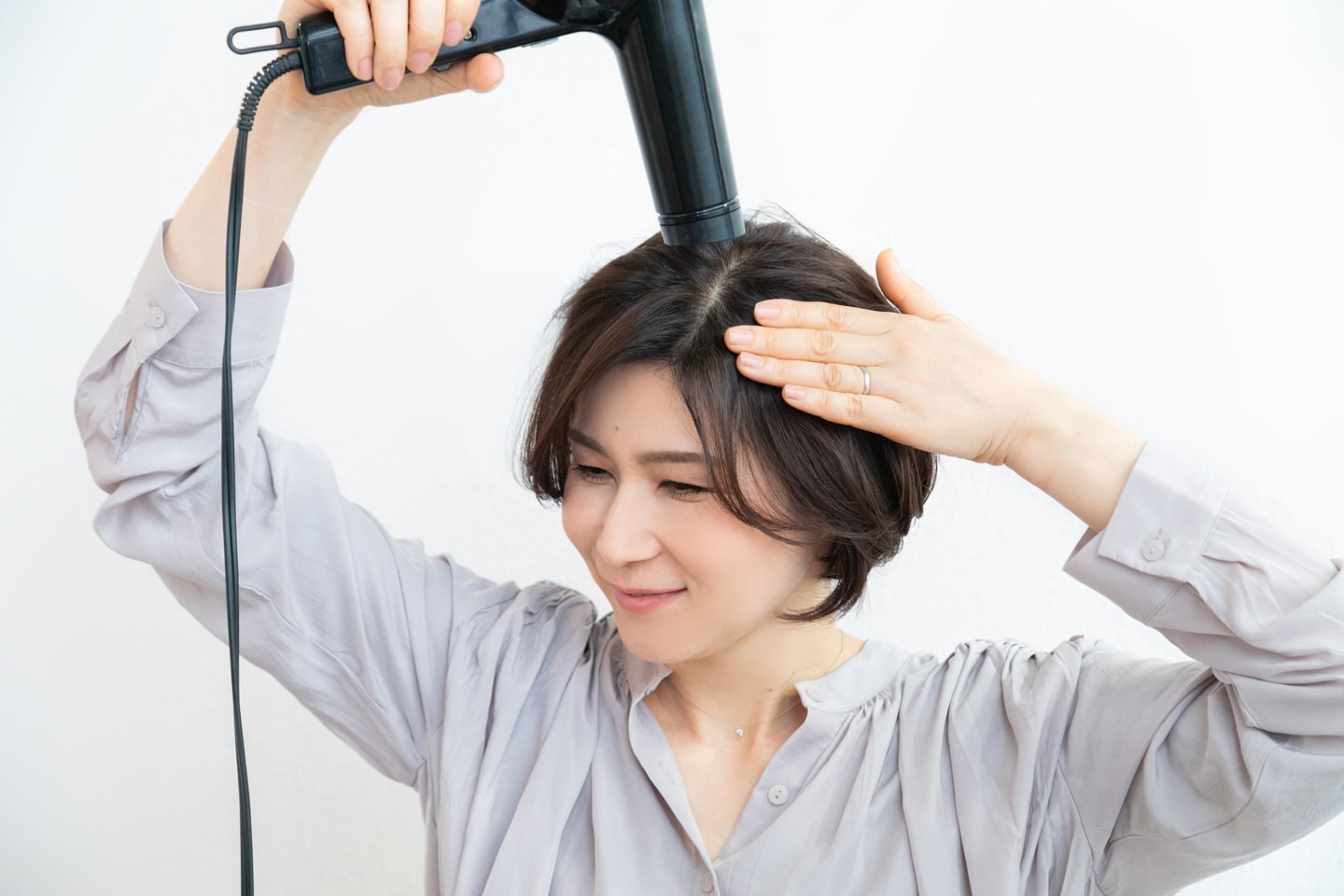 襟足とハチ周りは手で押さえながら、上からドライヤーの風を当ててタイトに乾かす。