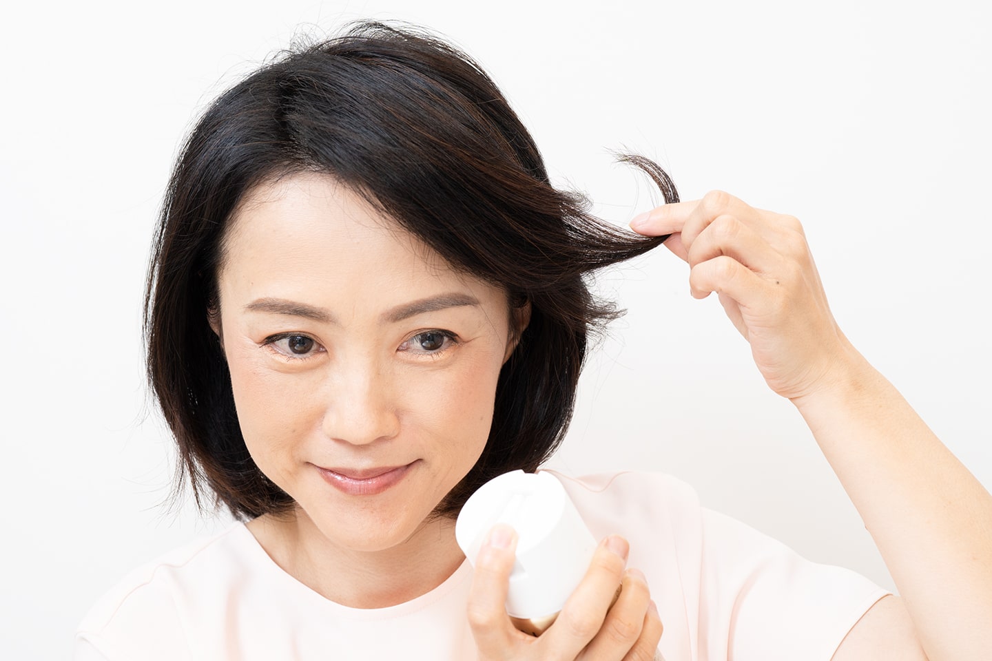 毛束を反り返らせるようにつまみながら、30㎝ほど離してスプレーする。