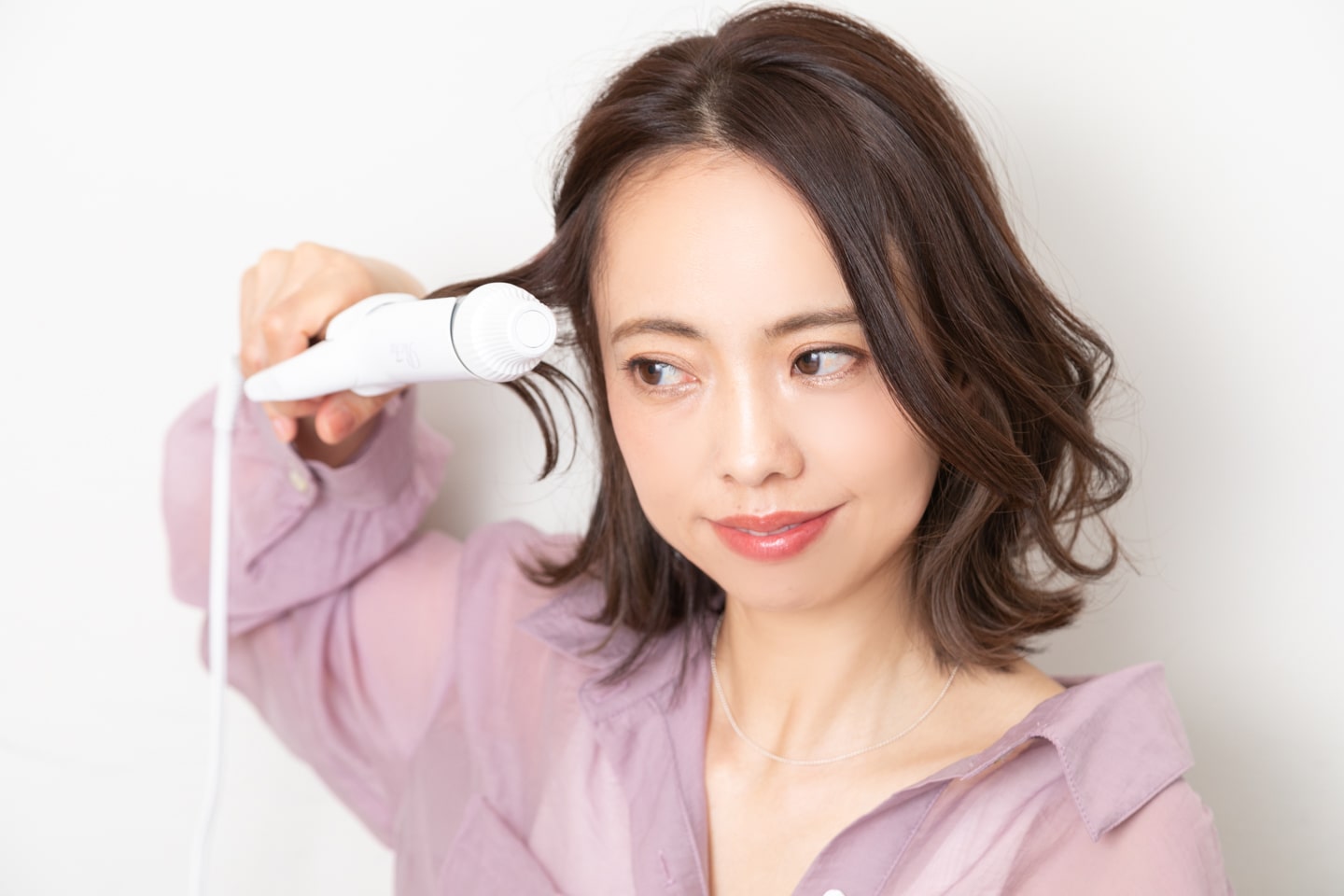 もみあげ辺りの毛を一束取り、S字になるように巻く。