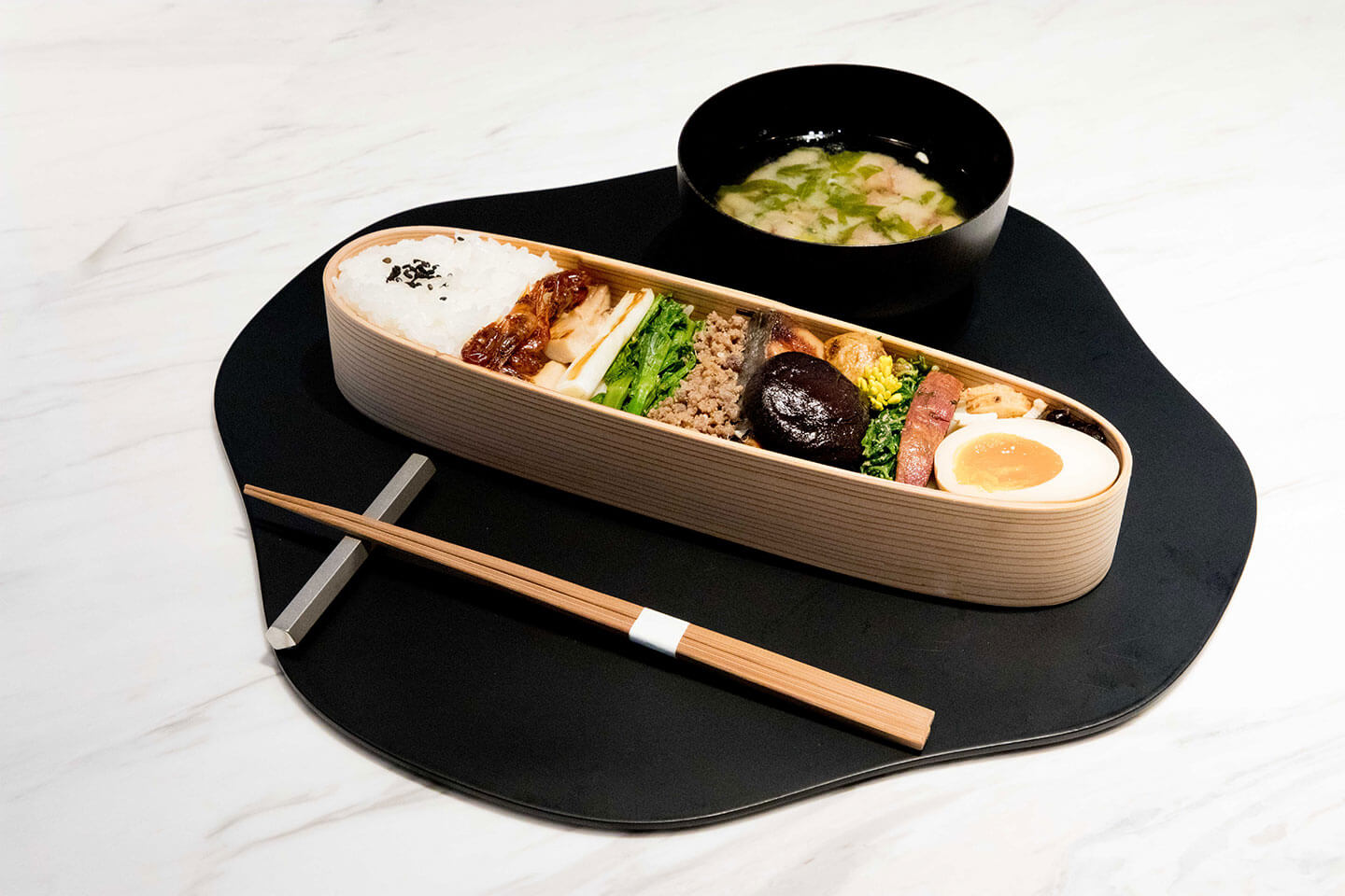 「古来種野菜のお弁当」¥1,800。季節の古来種野菜を「生」「煮」「焼」「蒸」「揚」の五法で調理したおかず、日替わりの焼き魚、椎茸の含め煮や煮たまご、牛そぼろなど5種類の定番おかずなどが詰められている。