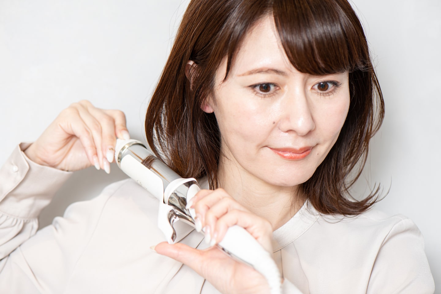 32mmのヘアアイロンを使用。毛先から平巻きで1回転して、全体に外ハネを作る。