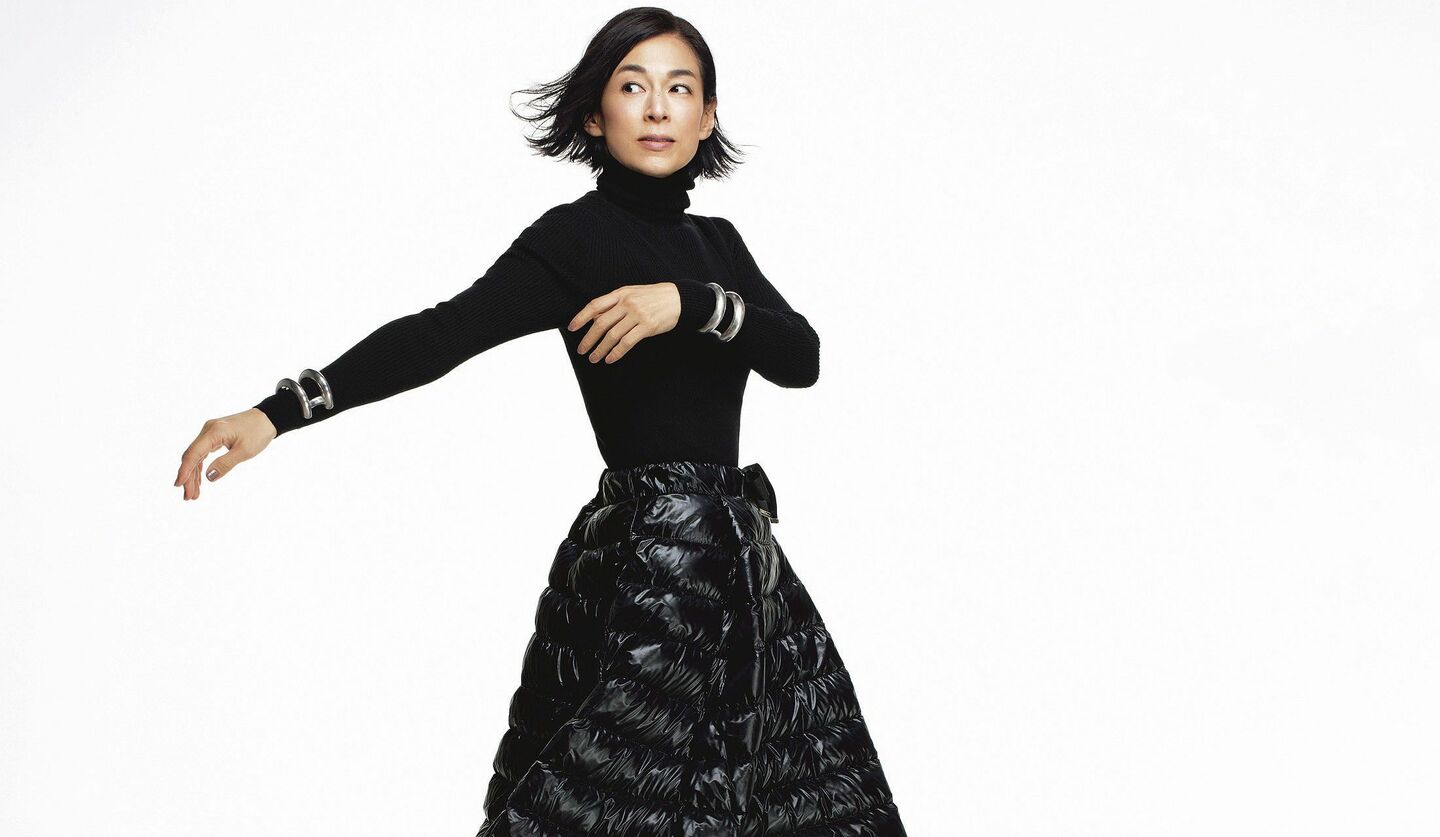 シンプルな黒タートルにダウン素材のスカートを着ている鈴木保奈美さんの写真