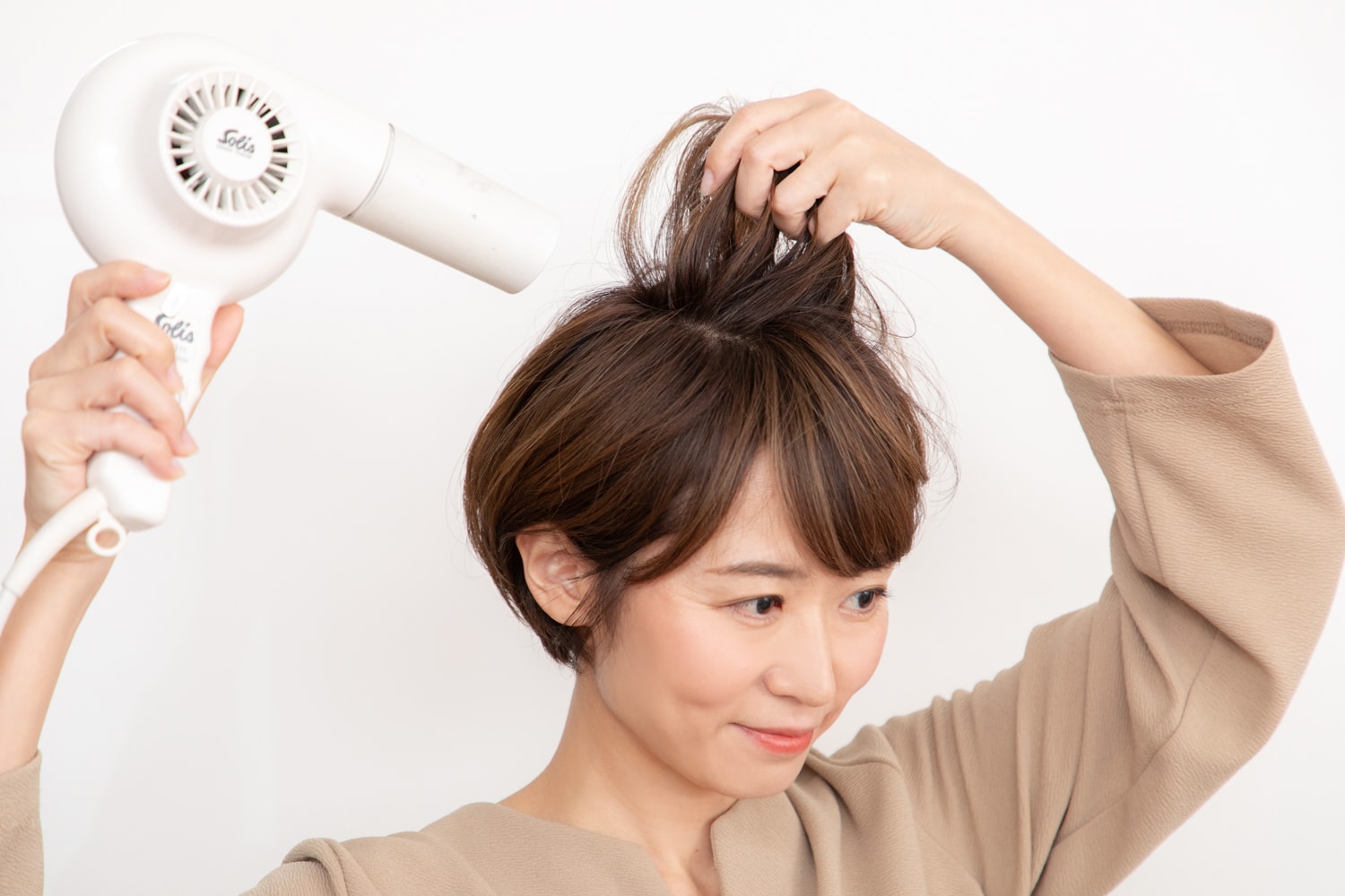 8割程度ザッと乾かしたら、ハチ上は根元を立ち上げながらブロー。トップは分け目に逆らって風を当ててふんわりと。ハチ下は広がらないように押さえて乾かす。