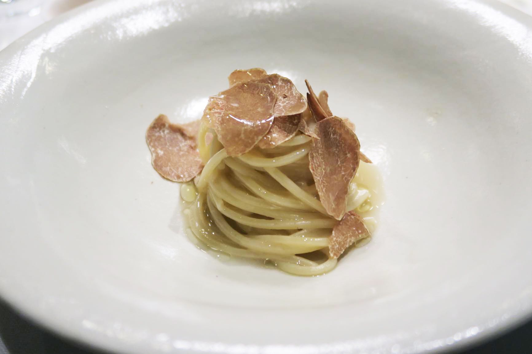 「アサリと骨髄のスパゲッティ」アサリからとったスープの中で太めのスパゲッティを煮込み、最後に牛の骨髄から抽出したエキスを注ぐ。それだけでも十分おいしいのだがとどめはアルバ産の白トリュフ