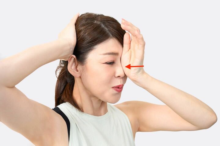 左手の手根で鼻の左側面をプッシュする