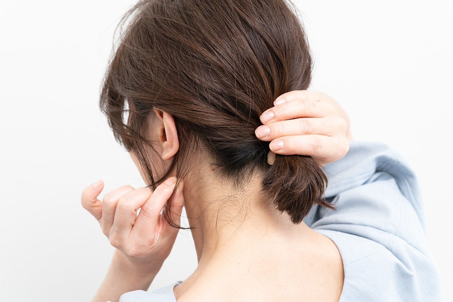 結んだ毛束を抑えながら、耳裏、襟足を少しずつつまんで引き出す。生え際に沿って引き出していくと綺麗にまとまる。