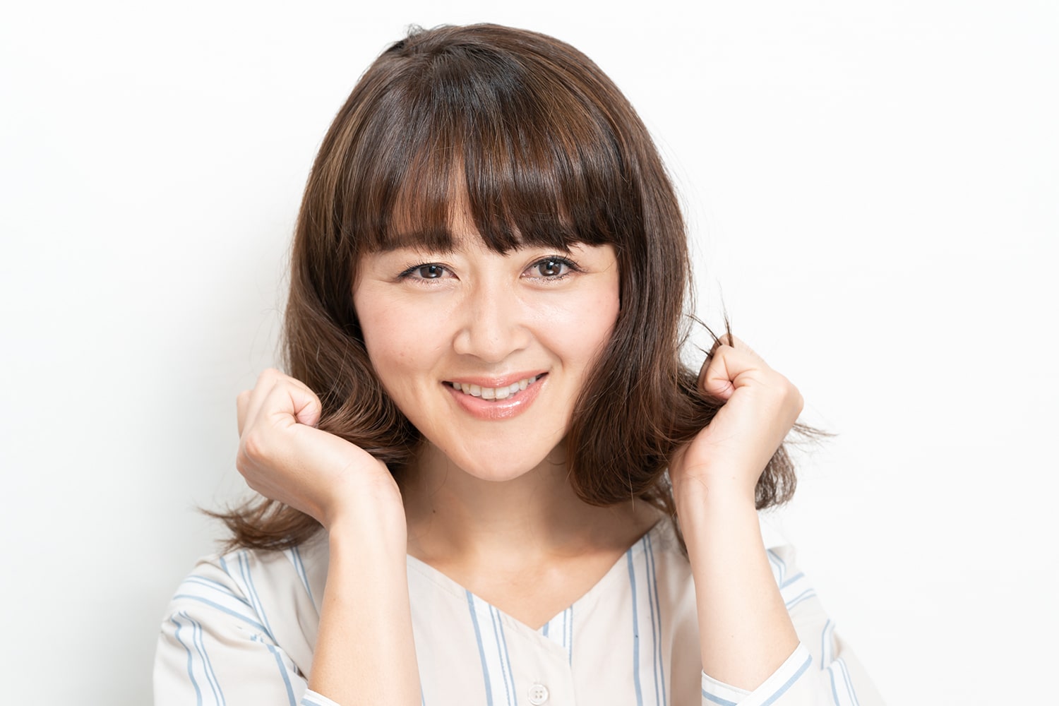 バームを手のひらにしっかりとなじませたら、毛束の中間から毛先にまんべんなく揉み込む。