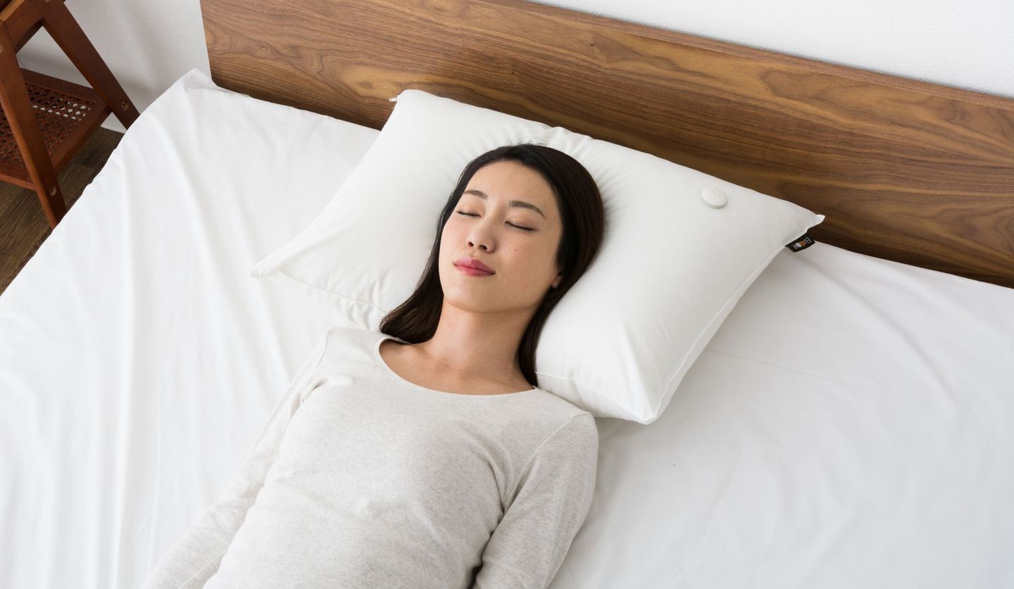 「エムール スリープ ドット」を枕元に置いて眠る女性