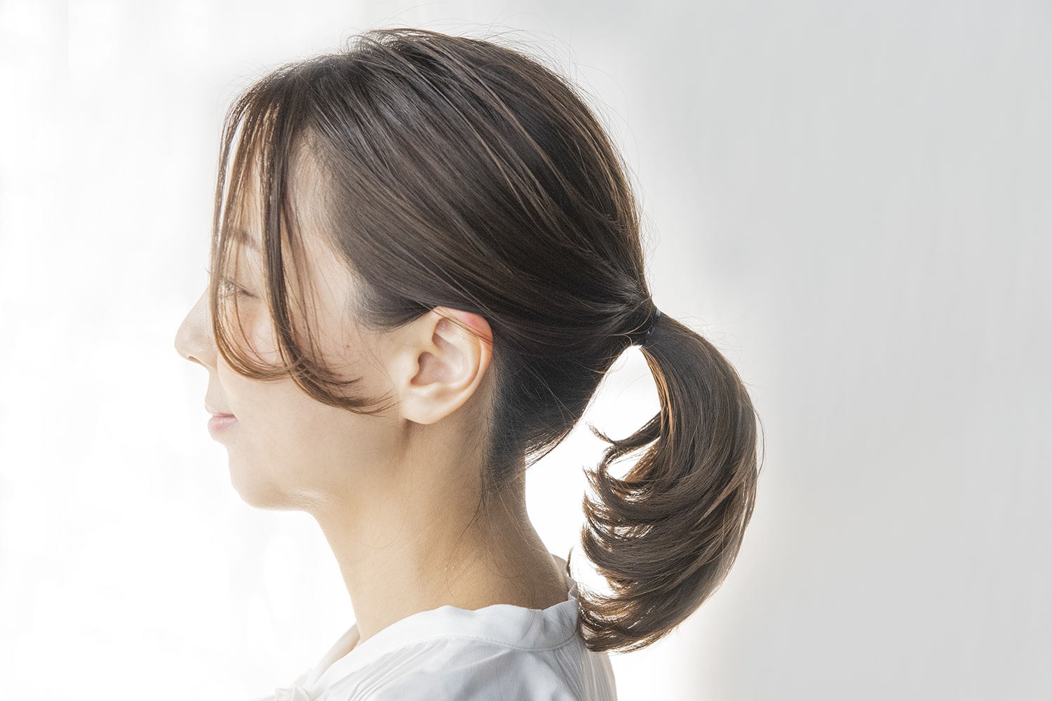 耳の高さで髪をまとめてゴムで結ぶ。襟足はタイトになるように意識して。