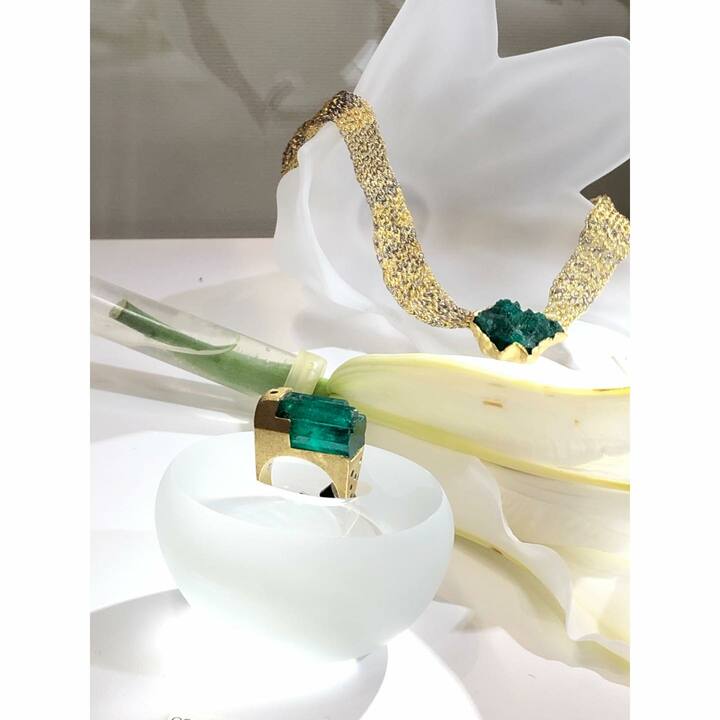 ［手前］リング「碧の音」エメラルド25.3ct ￥4,104,000、［奥］ネックレス「in my heart」エメラルド30.96ct ￥3,780,000