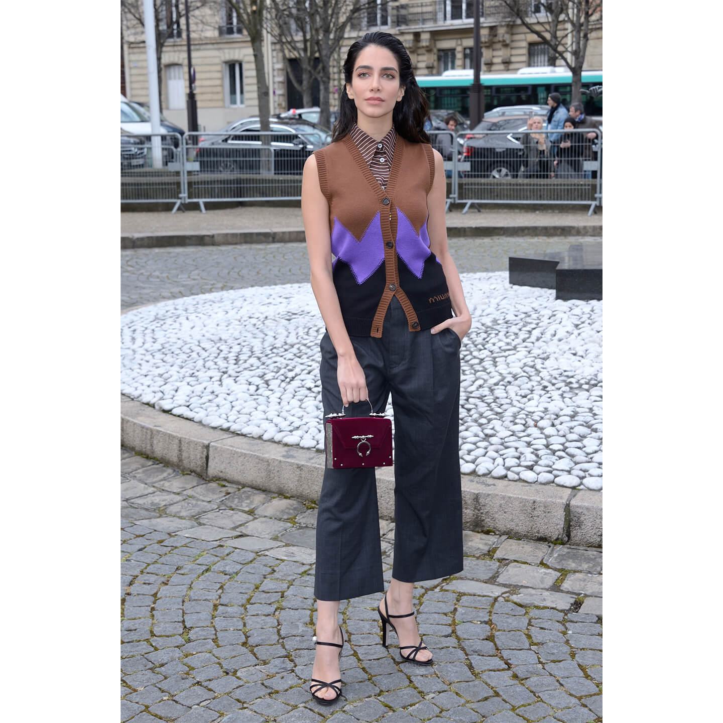 ノースリーブのシャツにニットのベストを着た女性