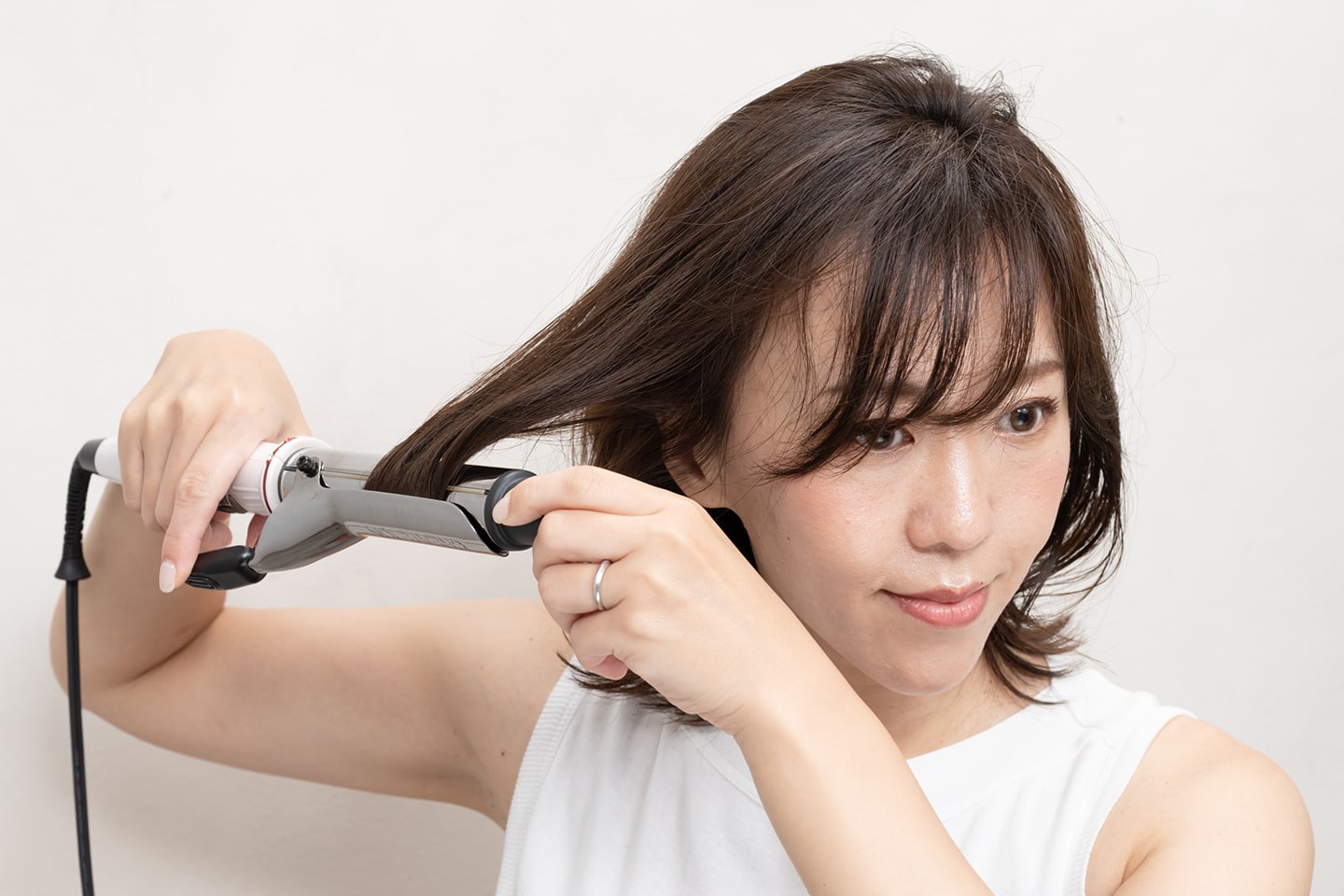 毛束をざっくり取って毛先を内巻きに。全方位巻いて。