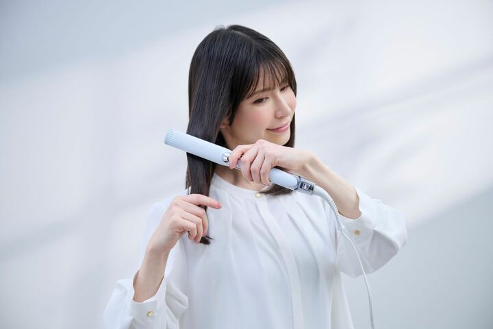 「リファ ストレートアイロン プロ」を使いヘアスタイリングをする女性