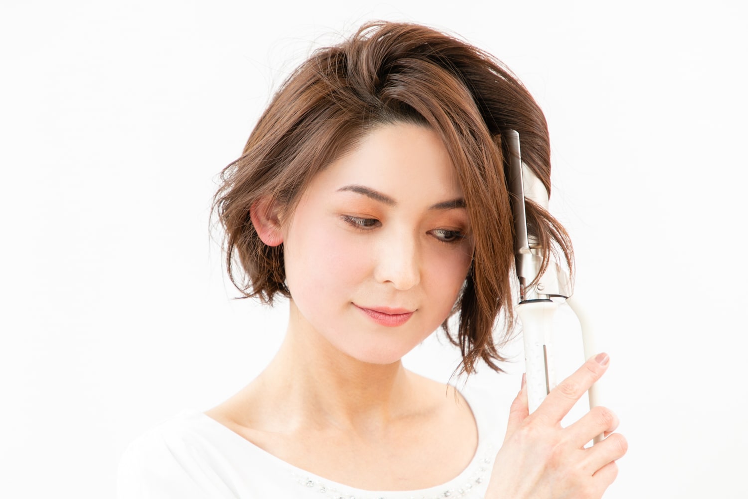 28mmのヘアアイロンを使用。毛先が出る内側の髪は外ハネにワンカールさせ、表面の髪はやや縦に巻いて内巻き&外巻きをランダムに作る。
