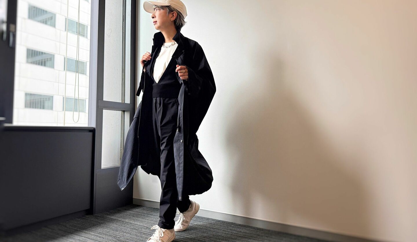 濃紺のコートに白Tシャツ、黒のニットベスト、黒のパンツのコーディネート