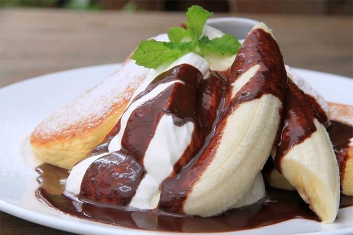 パンケーキやバナナの味わいを引き立たせるビターチョコレートとまるごと1本のバナナ、ホイップの絶妙なコンビネーションがたまらない『バナナホイップパンケーキチョコソース添え』 ¥1,200