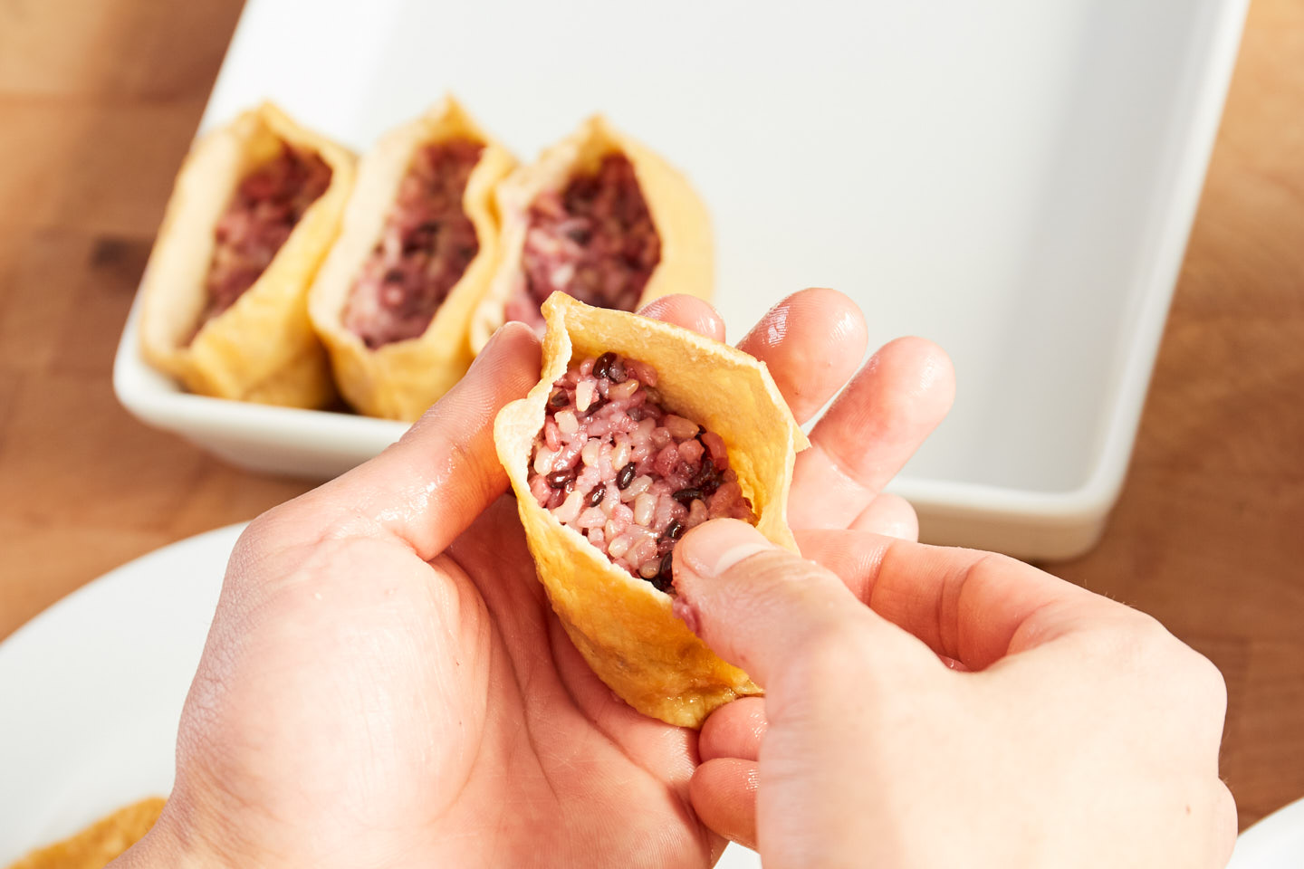 いなり揚げにご飯を詰める工程