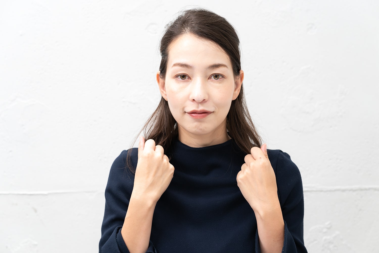ミルクタイプのワックスをなじませた手で、毛先をくしゅくしゅと握りながらクセをつける。