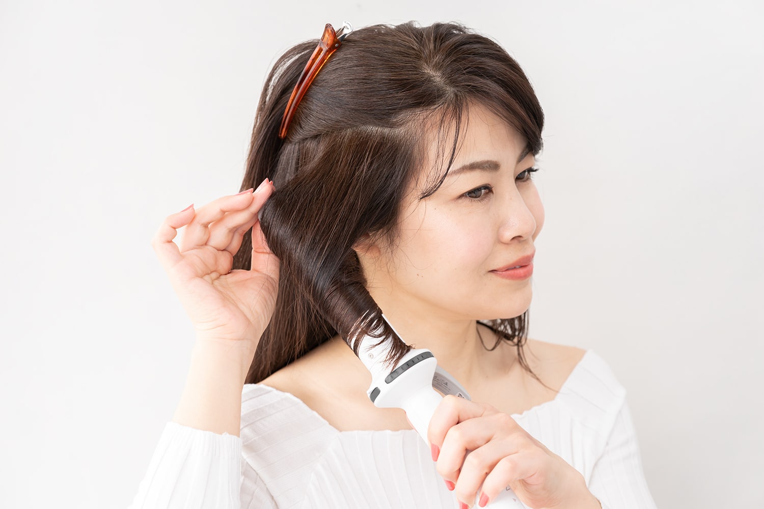 コテは36mmを使用。毛束を多めにとって中間をしっかりと巻く。ハチ上を留めておくとやりやすい。逆サイドも同様に巻いて。