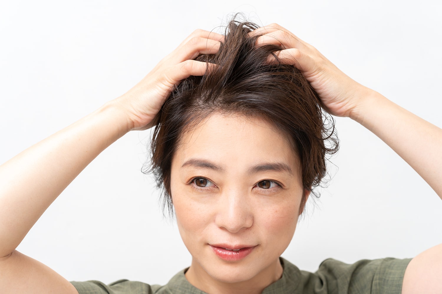 両手のひらにワックスを広げ、髪を揉み込むようにしてなじませる。