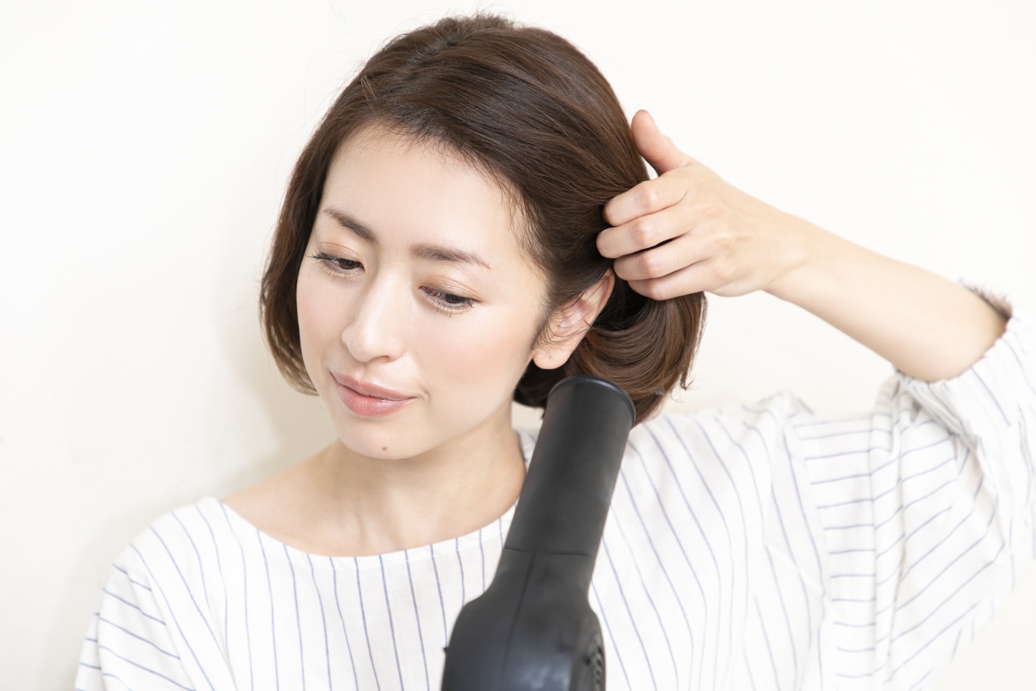 サイドの髪の根本に下から温風を当て、ふんわりとボリュームを出す。