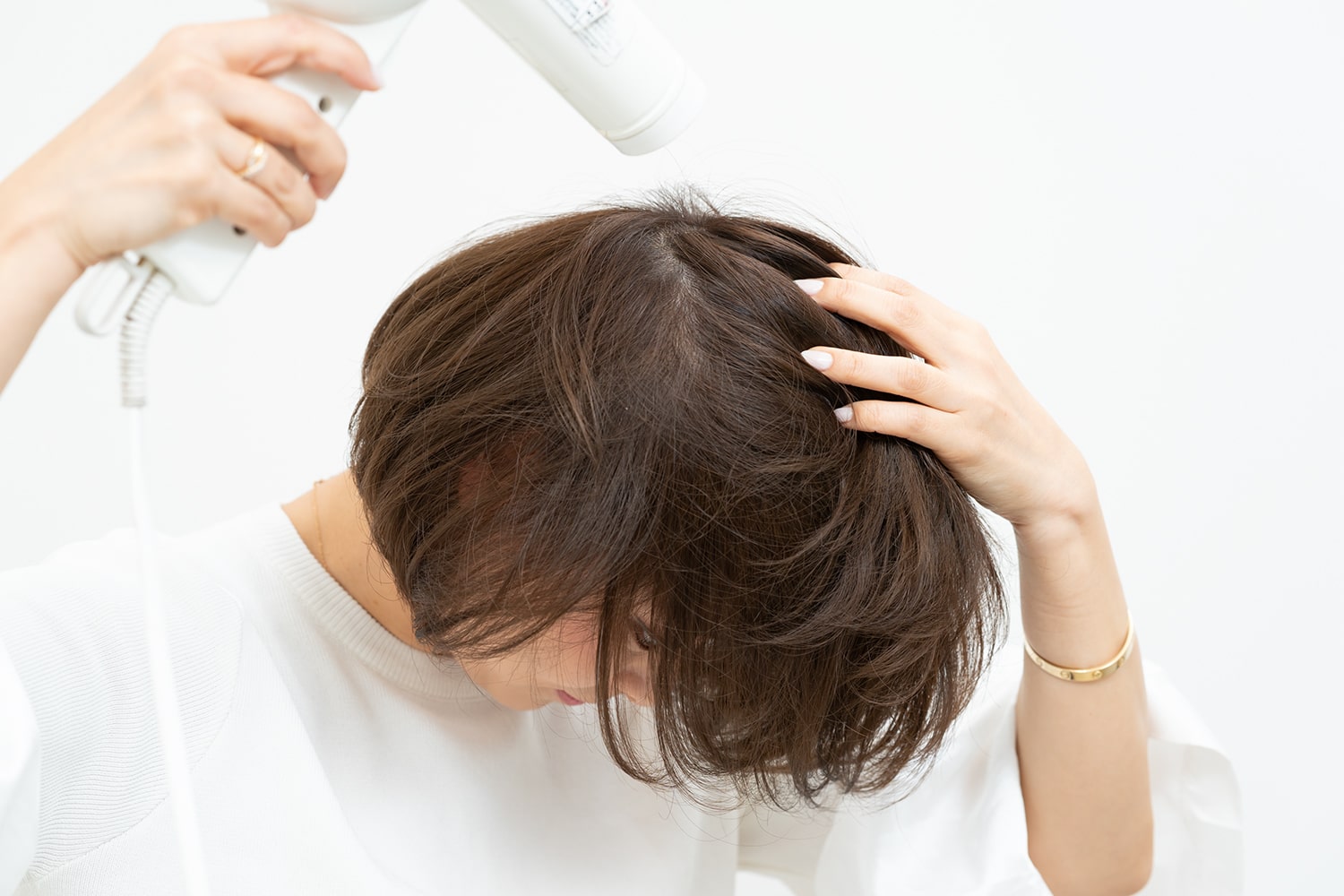 前方に向けて乾かすと髪全体の根元が起き上がる。地肌をこするように手ぐしでとかして。